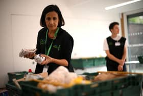 The Trussell Trust hand out more than 400 emergency parcels to hungry children each week in Sheffield. Pictured here is a member of staff sorting through food items inside a foodbank in Hackney, north-east London. (Photo by DANIEL LEAL/AFP via Getty Images)