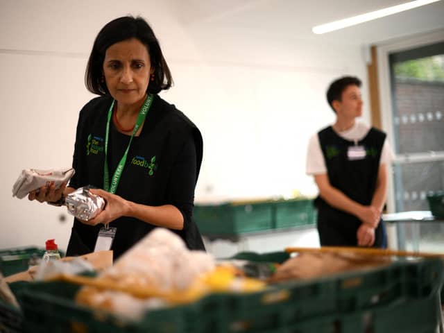 The Trussell Trust hand out more than 400 emergency parcels to hungry children each week in Sheffield. Pictured here is a member of staff sorting through food items inside a foodbank in Hackney, north-east London. (Photo by DANIEL LEAL/AFP via Getty Images)