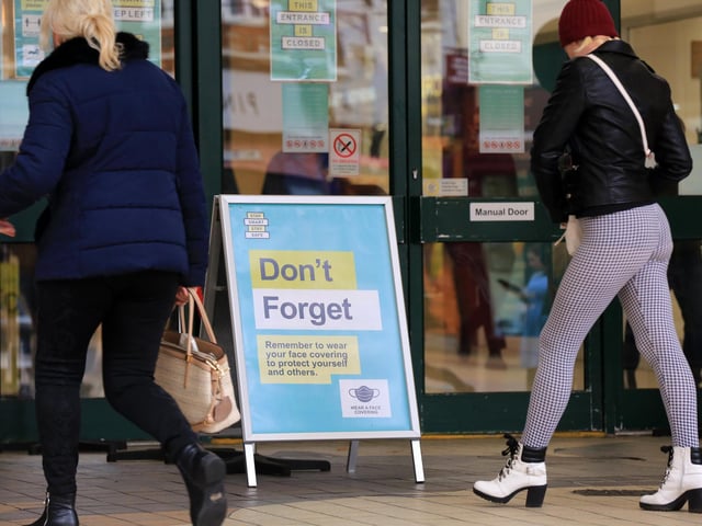 Signs reminding shoppers to wear face coverings