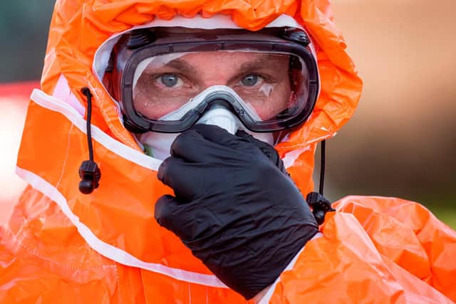 A Polish health official wears protective clothes as he checks the temperature of Poles returning home at the Polish-German border from the eastern German town of Frankfurt (Oder) to Slubice on March 16, 2020, as measures are taken to slow down the spread of the novel coronavirus. (Photo by ODD ANDERSEN/AFP via Getty Images)