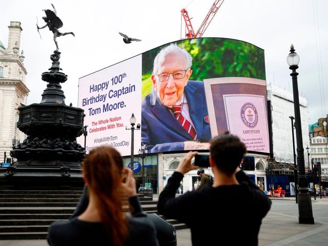 A birthday message for Captain Tom Moore is displayed on the advertising boards in Piccadilly Circus in London on April 30, 2020 as the country celebrates his 100th birthday. (Photo by Tolga Akmen / AFP)