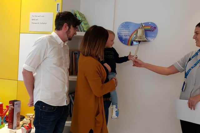 Alfie, with mum Emma and dad Aaron, ringing the bell on the cancer ward, following his treatment