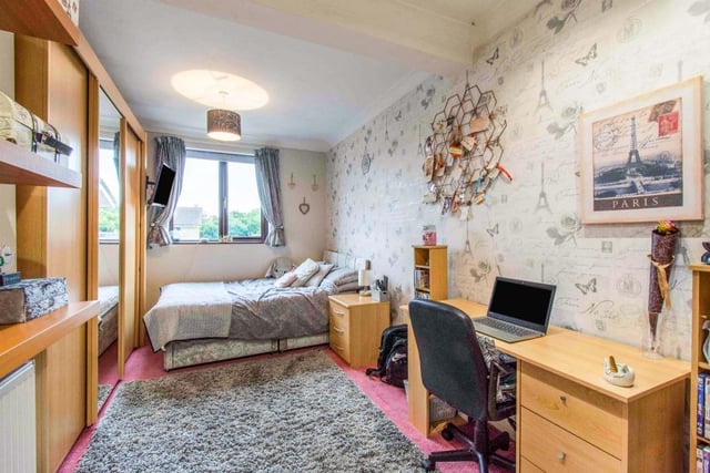 A double room with a front facing double glazed window, a range of fitted wardrobes, partial downlights to the ceiling, a central heating radiator and floor to ceiling storage cupboard.