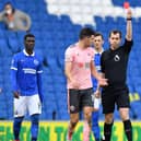 Referee Peter Bankes (R) shows a red card to Sheffield United midfielder John Lundstram (L) during the Premier League football match between Brighton and Hove Albion and Sheffield United at the American Express Community Stadium in Brighton  (Photo by GLYN KIRK/POOL/AFP via Getty Images)