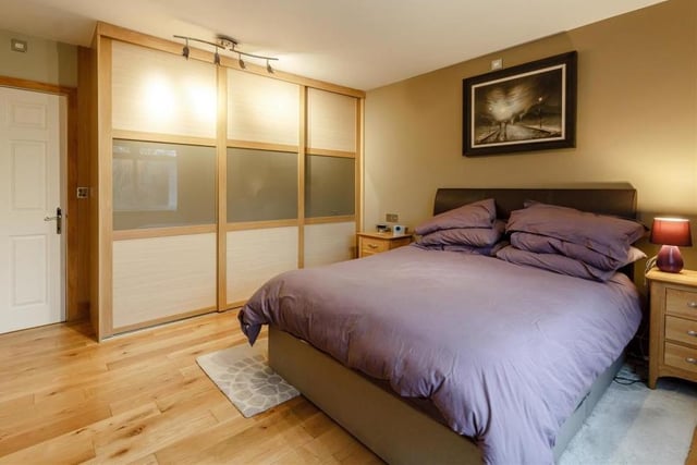 The delightful master bedroom boasts a substantial range of contemporary fitted wardrobes, with hanging rails, shelving and 'soft close' sliding doors. The floor is solid oak, the window looks out on to the back garden, and another sliding door leads to a large en suite bathroom.