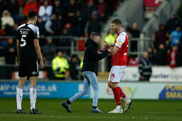 Rotherham United's Michael Smith confronts a pitch invader during his side's Sky Bet League One match against Accrington Staley at AESSEAL New York Stadium. Picture: Will Matthews/PA Wire.