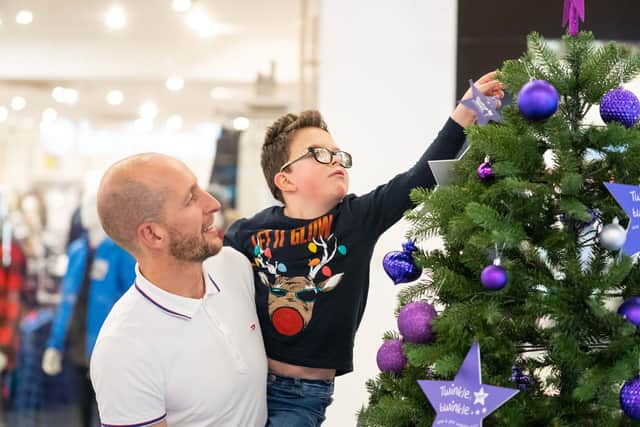 Jacob hangs the first star on the Bluebell Giving Christmas tree at Meadowhall Shopping Centre, Sheffield, as the Christmas lights were turned on for 2021.