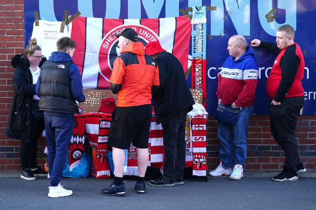 Blades fans look over a selection of pin badges ahead of the Bristol City game