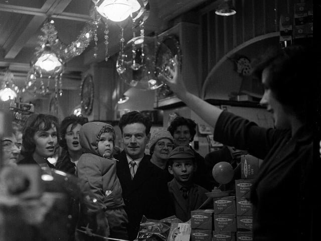 A sales girl demonstrates the latest plastic toy balloon-making kit in an Edinburgh toy shop in 1962.