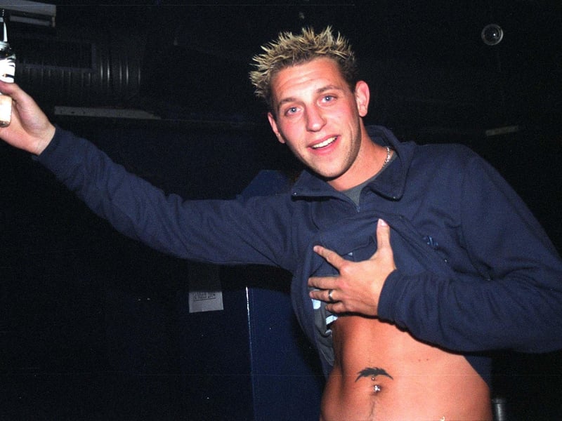 A reveller at Sheffield's Club Zero lifts his top to show off his tattoo on a night out in 2004