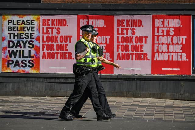 Two police officers walk past posters on Sauchiehall Street during the coronavirus lockdown (Photo by Jeff J Mitchell/Getty Images)