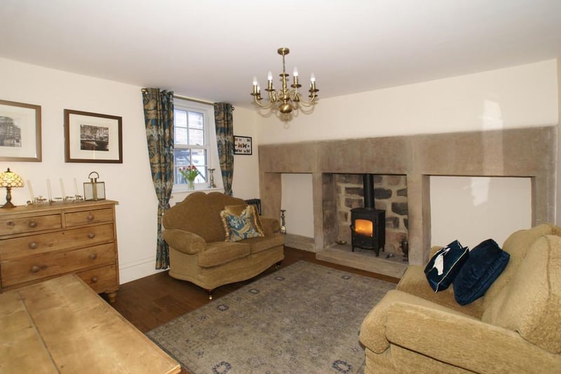 The sitting room has a rear-aspect UPVC double-glazed sliding sash window, light oak flooring, and a cast iron column central heating radiator. A feature of the room is the original fireplace, formerly the kitchen's and having three fire openings with heavy dressed gritstone lintels and side supports. The centre fire opening houses a Clearview multifuel stove.
