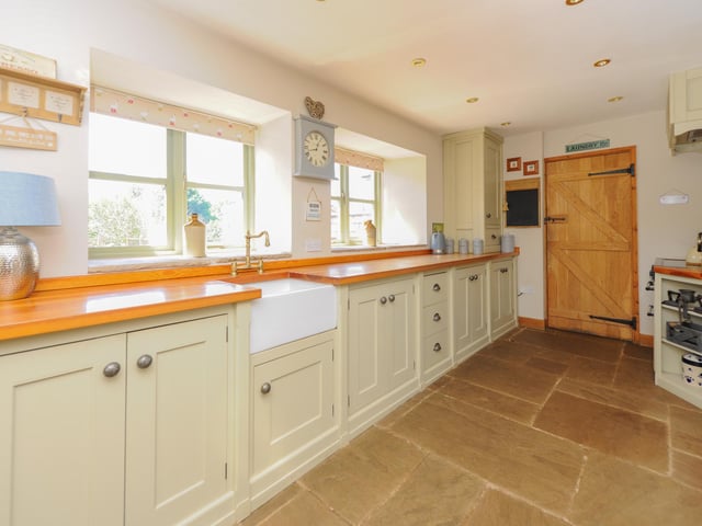 The bespoke kitchen has a Belfast sink and solid wood worktops.