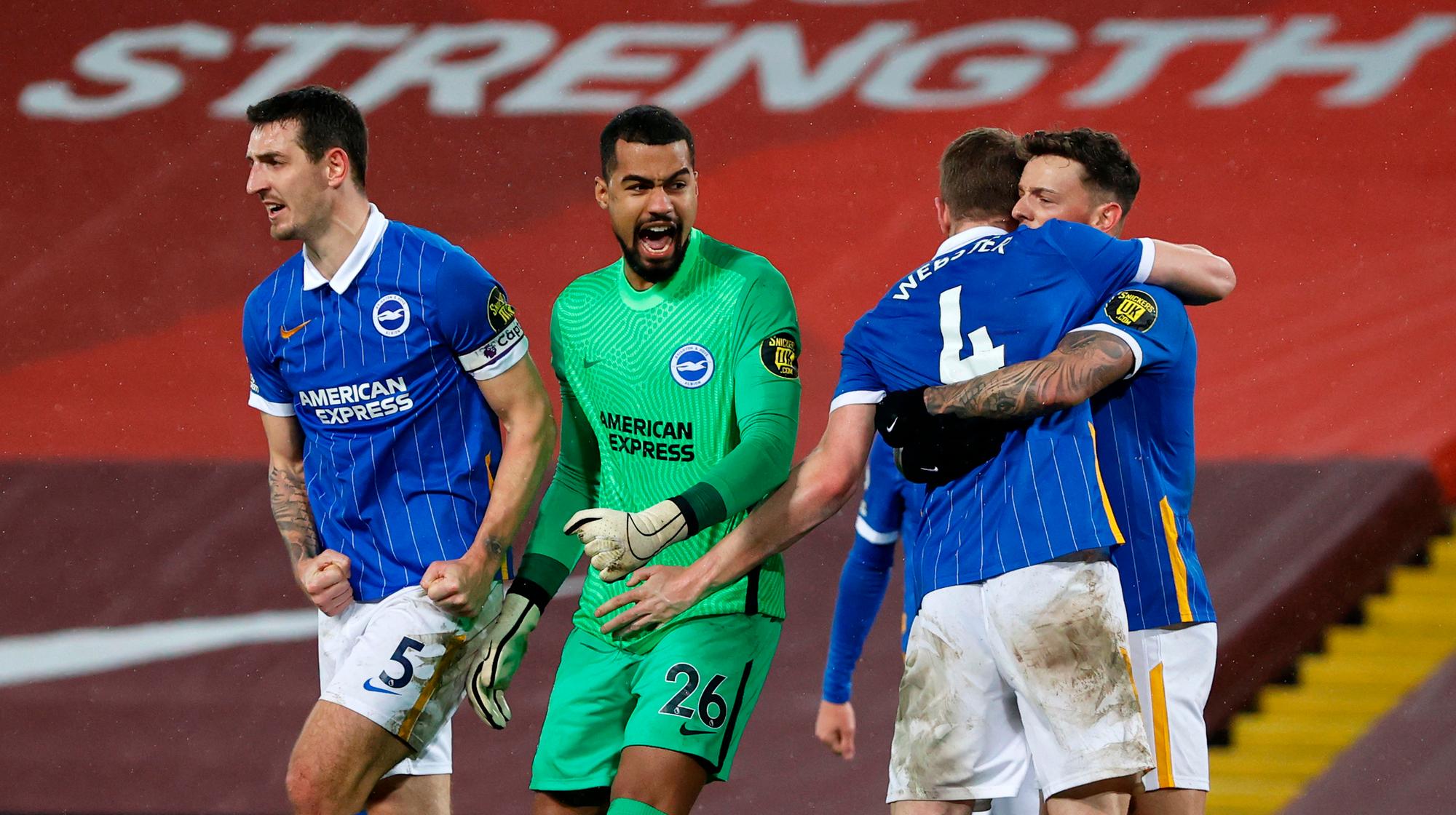 Brighton's Spanish goalkeeper Robert Sanchez (2L), celebrates with Brighton's English defender Lewis Dunk (L) and Brighton's English defender Adam Webster (2R) after the English Premier League football match between Liverpool and Brighton and Hove Albion at Anfield in Liverpool, north west England on February 3, 2021. - Brighton won the match 1-0. (Photo by PHIL NOBLE / POOL / AFP) / RESTRICTED TO EDITORIAL USE. No use with unauthorized audio, video, data, fixture lists, club/league logos or 'live' services. Online in-match use limited to 120 images. An additional 40 images may be used in extra time. No video emulation. Social media in-match use limited to 120 images. An additional 40 images may be used in extra time. No use in betting publications, games or single club/league/player publications. /  (Photo by PHIL NOBLE/POOL/AFP via Getty Images)