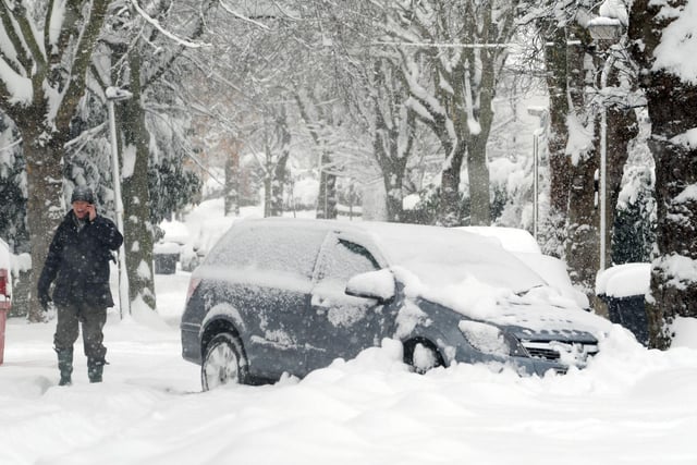 A pedestrian passes a abandon vehicle in Whirlowdale Road, Millhouses, Sheffield during heavy snow fall back in December 2010