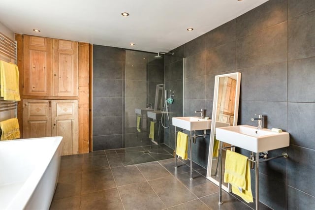This is another shot of the stylish family bathroom. You can clearly see the fully tiled, walk-in shower and also two wash hand basins with chrome fittings.
