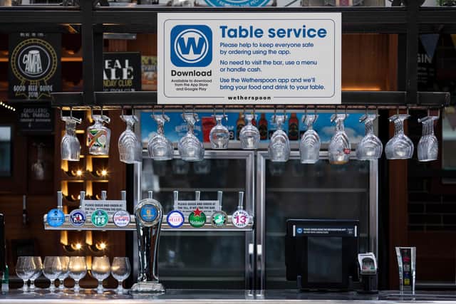 A table service sign above the bar at a branch of Weatherspoons. (photo by Dan Kitwood/Getty Images)