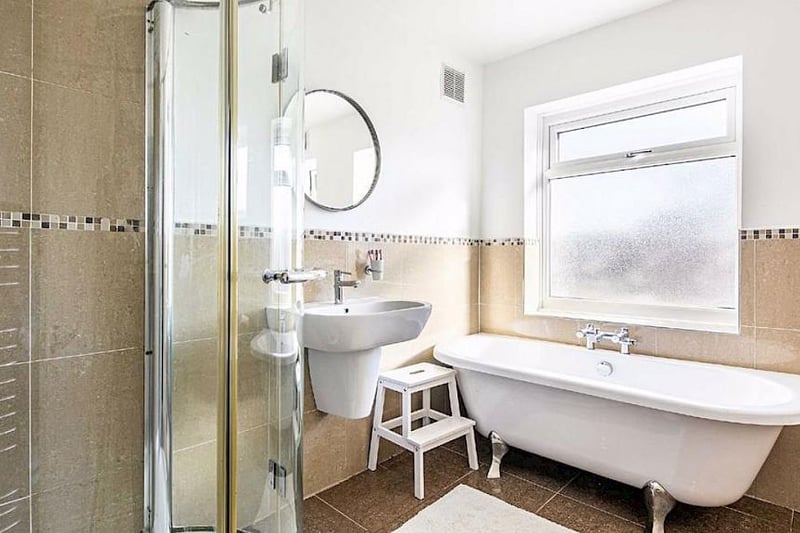 The family bathroom has a white suite that includes a freestanding bath and a separate shower enclosure.