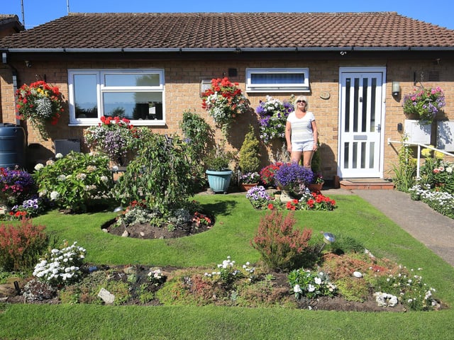 In August, Peter Evans, of Somersby Court, Mansfield, wanted to praise his neighbours for making their gardens look so wonderful and a reason to smile in a tough year. Pictured is Eireen Brooks with her garden.