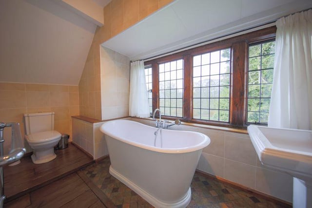 A newly installed bathroom enjoys garden views from a roll top bath.