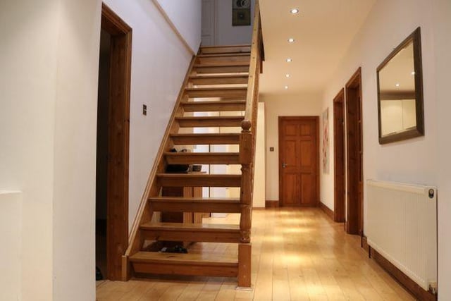 They hallway features a hardwood door, laminate flooring, video entry system and radiator