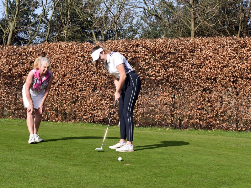 Lady captain Kay Vickers and Ellie Parker practice on one of the club's two putting greens.
