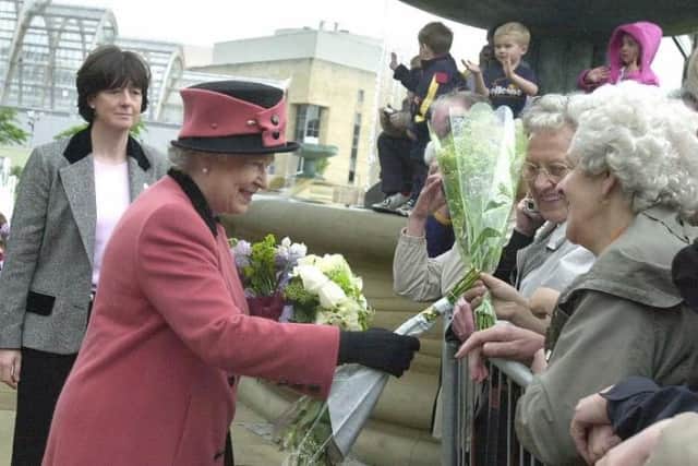Queen Elizabeth II greeting people who came out to see her during Her Majesty's visit in 2003.