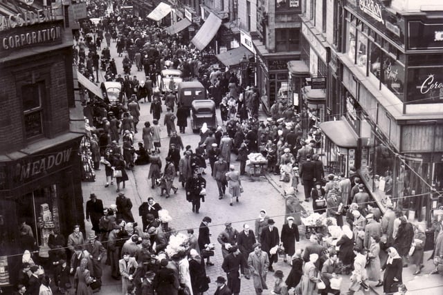 Dixon Lane, Sheffield pictured in 1950.  Caption reads "There's something lively and "matey" about a shopping crowd.  Let's keep the town alive a little later, on Saturday's at any rate".