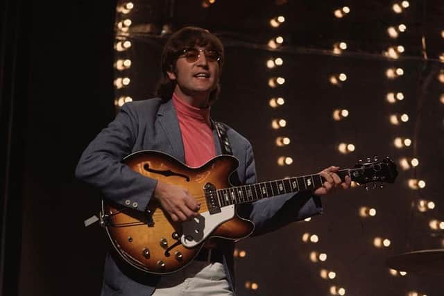 1966:  Beatles singer, songwriter and guitarist John Lennon (1940 -1980) performing against a lit backdrop.  (Photo by Keystone/Getty Images)