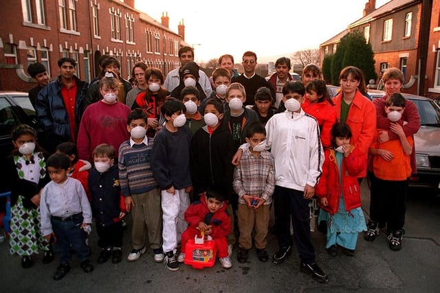 Pictured are children and residents with their masks in the street because of the pollution on the streets at Tinsley. Also pictured centre with glasses is Mohammed Ghazi organiser, February 1998