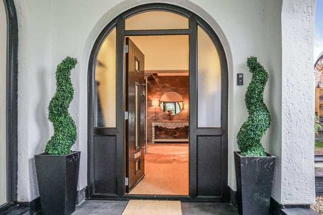The entrance porch leads into an atrium-style reception hall with a semi-circular staircase in Venetian plaster.