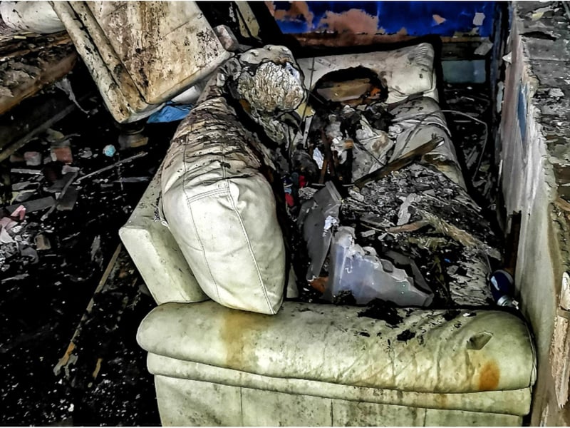 Wrecked furniture remains within the building.