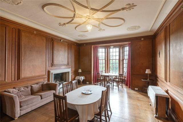 This dining room has a feature ceiling rose and bay windows.