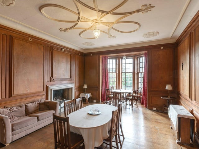 This dining room has a feature ceiling rose and bay windows.