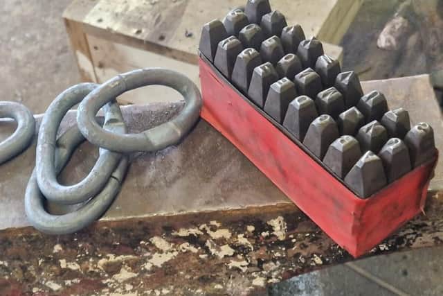 Hand-forged chain links ready for stamping on a Ridgeway Forge anvil