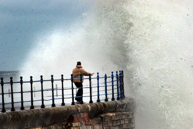 A lone walker tries a walk along the pier on the Headland in Hartlepool in the storms of 2004.