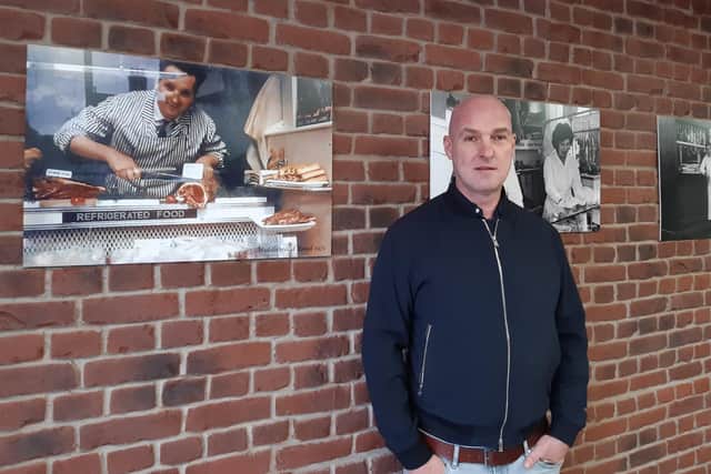 Richard Béres inside the new store in Broomhill, standing next to a photo of his father, Sandor.