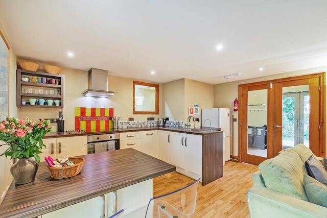 An open plan kitchen with modern units, including an integrated oven and hob.