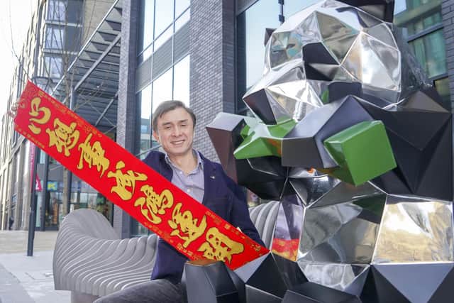 Jerry Cheung with a banner that reads 'Happy New Year for Chinese New Year at New Era Development in Sheffield' and a panda. Picture Scott Merrylees