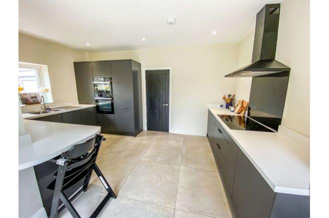 The contemporary kitchen/diner offers a range of wall/base units and integrated appliances, including fridge freezer, double oven, induction hob and dishwasher.