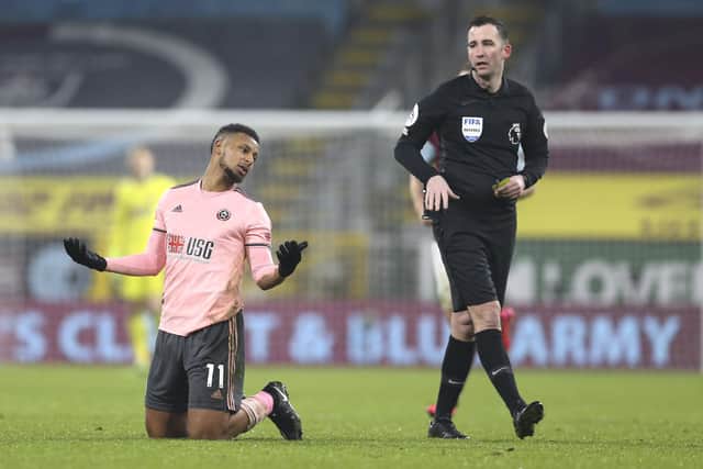 Sheffield United's Lys Mousset reacts as referee Chris Kavanagh passes by during the English Premier League soccer match between Burnley and Sheffield United: Barrington Coombs/Pool via AP