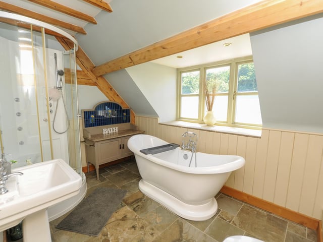 The bathroom has a separate shower and freestanding bath.
