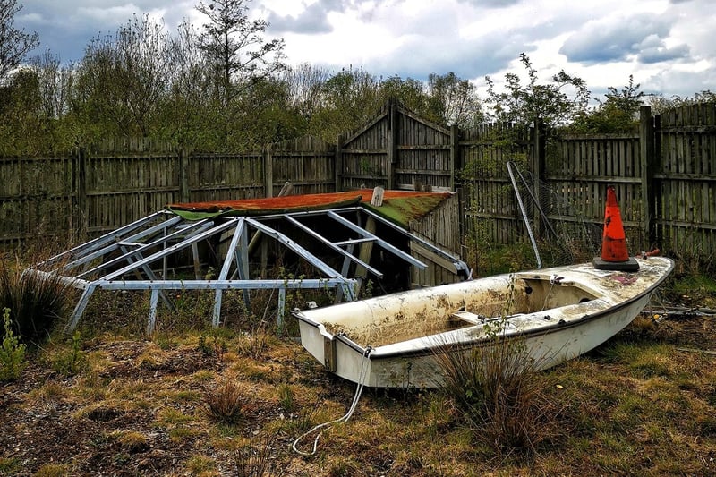 An old boat next to a piece of play equipment.