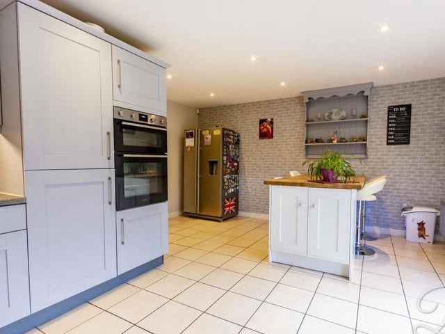 This is the kitchen from another angle. It features a gorgeous breakfast bar, plus a central-heating radiator.