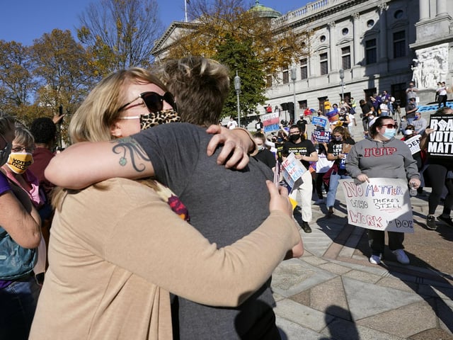 Jen Valley, of Hummelstown, Pa., and Carrie Fowler, of Harrisburg, Pa., embrace outside the Pennsylvania State Capitol (AP Photo/Julio Cortez)