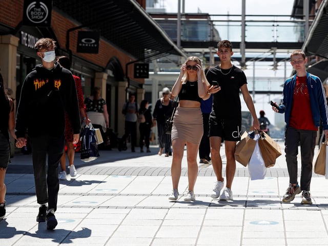 Shoppers, some wearing PPE (personal protective equipment), of a face mask or covering as a precautionary measure against COVID-19, walk past recently re-opened shops at Gunwharf Quays.