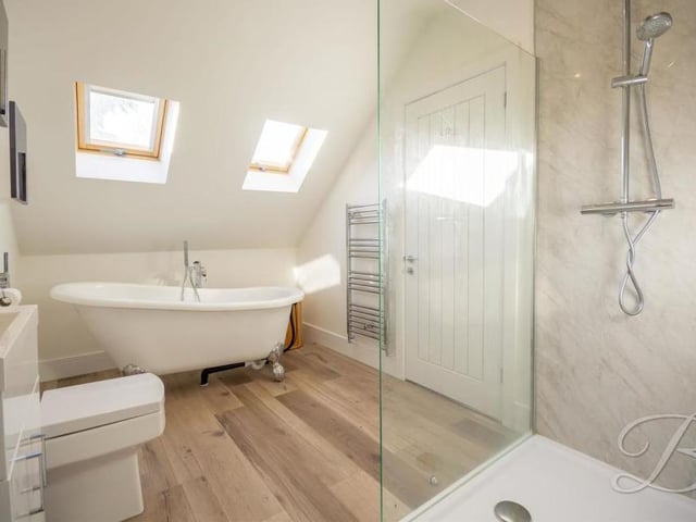 Here is the first of the en suites. An enclosed shower has full-height tiling, while a vanity wash hand basin, spotlights to the ceiling and laminate flooring add to its stylish appearance.