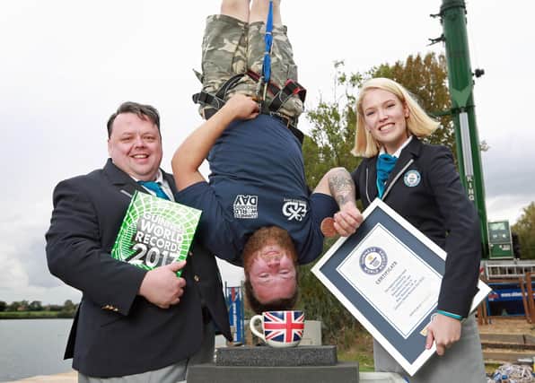 Simon Berry with the Guinness World Record for the highest dunk of a biscuit by a bungee jumper, which is 73.41 m (240 ft 10 in), at Bray Lake Watersports in Maidenhead, to celebrate Guinness World Records Day 2016. Photo: Matt Alexander/PA Wire
