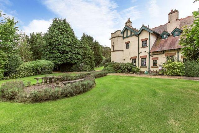 Landscaped garden grounds of around one acre offer secluded areas, alongside a large, partly walled croquet lawn with a patio seating area.