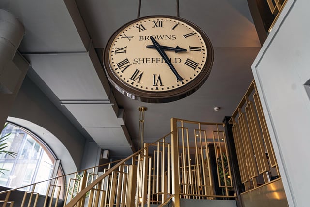 The interior features a railway station-style clock and a gold-coloured bannister up the stairs.